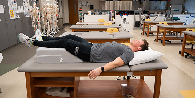 A student resting with his legs raised on a block